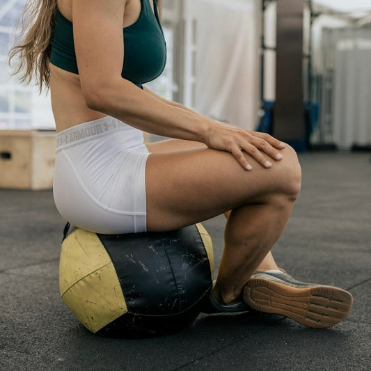 Woman using medicine ball for hip and core activation – gentle strength tool for home workouts