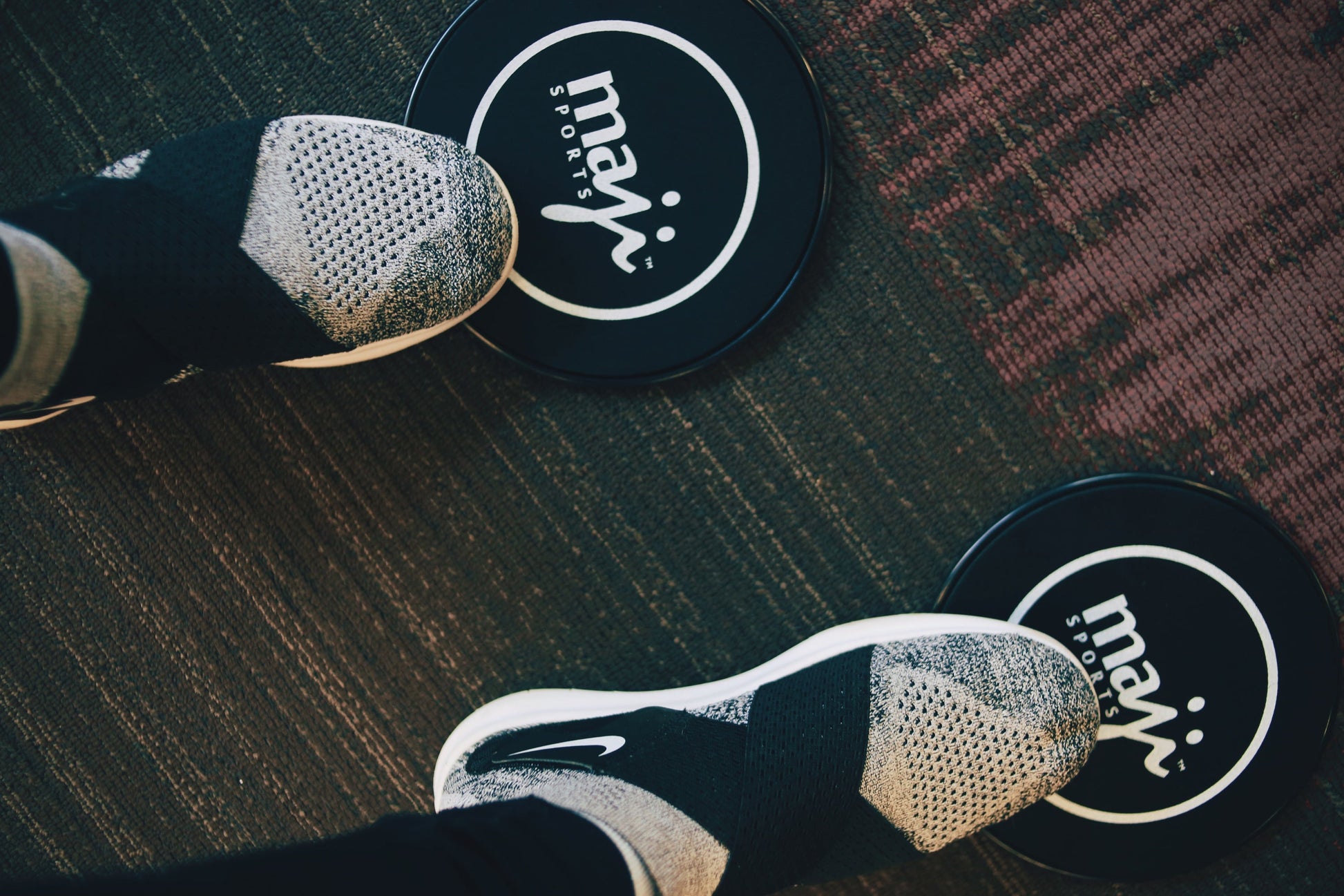 Feet positioned on core sliders – home training accessory for low-impact strength and stability
