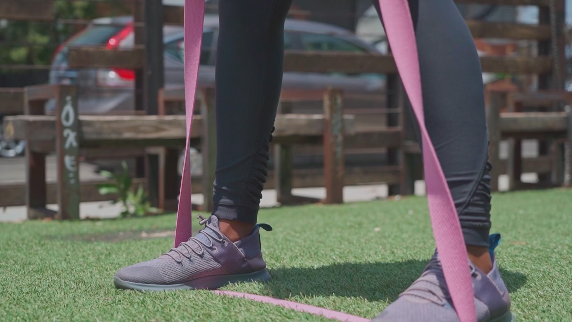 Person performing resistance band walk outdoors – gentle lower-body workout using long elastic bands for glute activation and mobility training